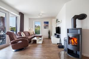 ein Wohnzimmer mit einem Sofa und einem Kamin in der Unterkunft Kirschgarten 9 - Seestern in Kellenhusen