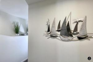 a shelf with a bunch of boats on a wall at Neue Liebe Haffkrug 4 in Haffkrug