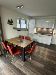 eine Küche mit einem Holztisch und roten Stühlen in der Unterkunft Neue Liebe Haffkrug 4 in Haffkrug