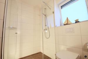 ein Bad mit einer Dusche und einem WC in der Unterkunft Neue Liebe Haffkrug 4 in Haffkrug
