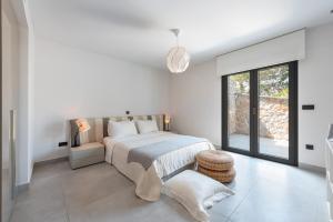 a bedroom with a bed and a large window at Villa Soligia Blue in Pefkali +52 photos