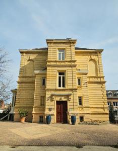 een groot houten gebouw met een rode deur bij Villa Valkenburg in Valkenburg