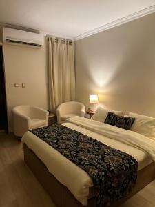een hotelkamer met een bed en een stoel bij Rentrific in Caïro