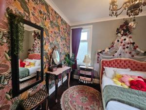a bedroom with two beds and a mirror at Flawsome stays Unique Edwardian Home near the Harbour and town perfect for Families up to 8 guests in Ramsgate