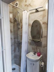 La salle de bains est pourvue d'un lavabo et d'une douche avec un miroir. dans l'établissement Kwatery Rydz, à Częstochowa