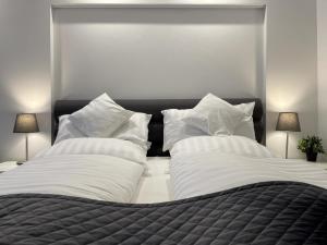 een slaapkamer met 2 bedden en witte kussens bij Maritim Residenz 6 - Sea Lounge in Travemünde