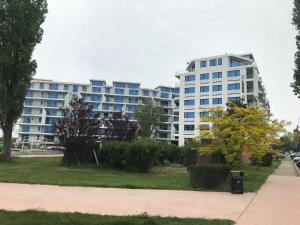 a large apartment building with a park in front of it at Ammos Apartment Mamaia in Mamaia