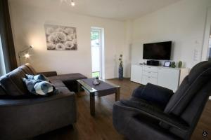 uma sala de estar com um sofá e uma mesa em NINA - Sonnenweg 20 em Heringhausen