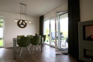 uma sala de jantar com uma mesa e cadeiras verdes em NINA - Sonnenweg 20 em Heringhausen