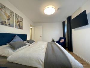 a bedroom with a large bed with a blue headboard at DAHMER STRAND No13 in Dahme