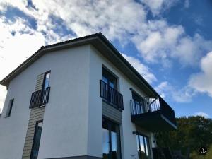 una casa bianca con balconi neri e cielo blu di Haus Paula - Sonnenweg 22 a Heringhausen