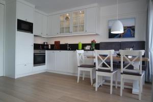 a kitchen with a dining table and white cabinets at Strandperle im Achterhus in Juist