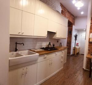 a kitchen with white cabinets and a sink at wawel hostel in Krakow +28 photos