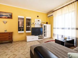 a living room with a bed and a television at Apartment Serđa in Ugljan
