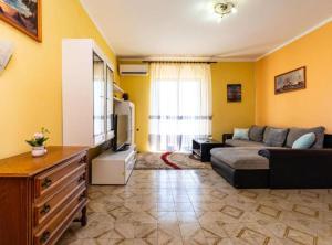 a living room with a couch and a tv at Apartment Serđa in Ugljan