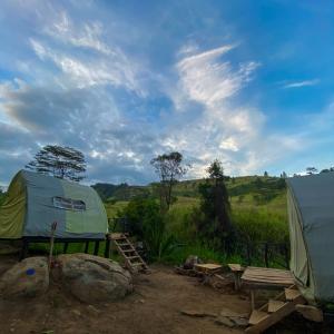 Galaha Town的住宿－Dunali Mountains Galaha，帐篷、桌子和田野长凳