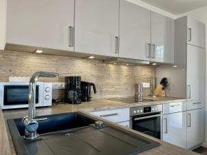 a kitchen with white cabinets and a kitchen sink at Sonnenweg 30 in Heringhausen