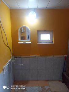 baño con pared amarilla y ventana en Laza guest house, en Laza