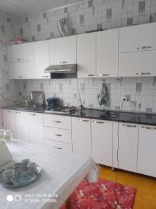 Laza guest house في Laza: مطبخ أبيض مع دواليب بيضاء وطاولة