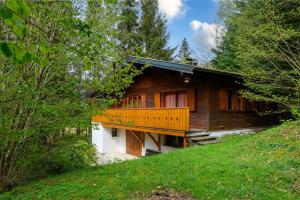 a wooden house with a balcony on a hill at Chalet Les Airelles in Mittlach