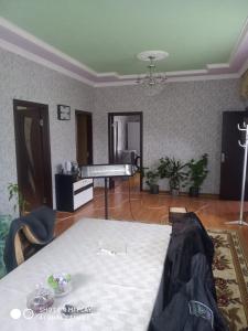 Laza guest house في Laza: غرفة معيشة مع طاولة وبيانو