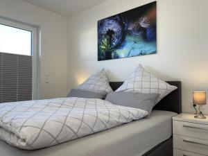 1 dormitorio con 1 cama y una pintura en la pared en Sonnenweg 11, en Heringhausen