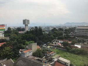 uma vista para uma cidade com edifícios e uma torre em 3BR Apartemen Sudirman Bandung em Bandung