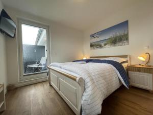 1 dormitorio con cama y ventana grande en Hansehaus 12 - MEERZEIT, en Grömitz