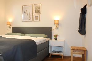 a bedroom with a bed and a night stand with a table at Sonnenweg 44-3 - HYGGE in Heringhausen