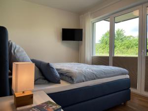 a bedroom with a blue bed and a window at Diemelblick 2 - TINNA in Heringhausen