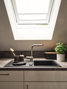 a kitchen with a sink and a skylight at LUCIES PLACE Kellenhusen in Kellenhusen