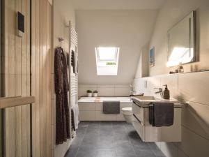 La salle de bains blanche est pourvue d'un lavabo et de toilettes. dans l'établissement LUCIES PLACE Kellenhusen, à Kellenhusen