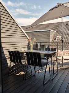 a table and chairs on a deck with an umbrella at LUCIES PLACE Kellenhusen in Kellenhusen