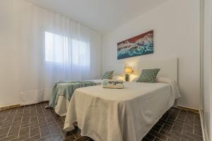 a white room with two beds and a table at DMS 5 1ª Planta Arysal 1 in Cambrils