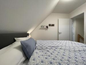 a bedroom with a bed with a blue pillow at Am Kutterhafen 24 in Fedderwardersiel