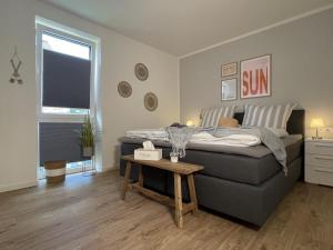 a bedroom with a bed and a table in it at Kellenhusen Tor 20 - STRANDQUARTIER in Kellenhusen