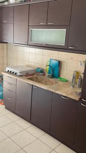 uma cozinha com armários castanhos e uma bancada em Friendly guest house em Tessalónica