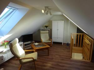 uma sala de estar com uma escada, um sofá e uma mesa em Lütten Uttied em Gollwitz