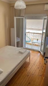 ein Schlafzimmer mit einem Bett und ein großes Fenster mit einer Terrasse in der Unterkunft Friendly guest house in Thessaloniki