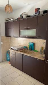 uma cozinha com armários castanhos e uma bancada em Friendly guest house em Tessalônica