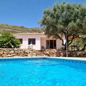 a villa with a swimming pool in front of a house at Finca Casa Emilia in Cómpeta