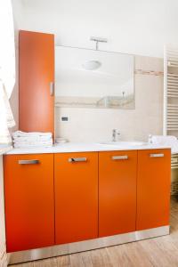 an orange bathroom with a sink and a mirror at Albergo Diffuso Magredi in Vivaro