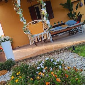 un jardín con una silla y flores frente a una casa en Dimora Virone Paradiso, en Naro