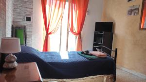 ein Schlafzimmer mit einem Bett und einem großen Fenster in der Unterkunft A Due Passi dal Centro in Trapani