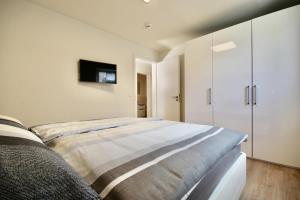 - une chambre avec un lit et une télévision murale dans l'établissement Kellenhusen Tor 11, à Kellenhusen