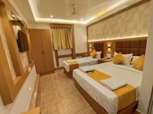 a hotel room with two beds and a television at Hotel Riva International Goregaon- Near NESCO in Mumbai