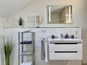 a white bathroom with a sink and a mirror at Kellenhusen Tor 6 in Kellenhusen