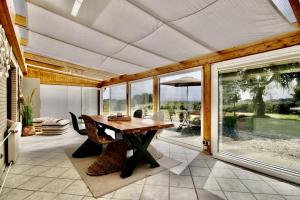 uma sala de jantar com uma mesa de madeira e janelas de vidro em Deichquartier em Oesterdeichstrich