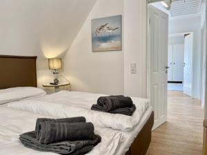 sypialnia z 2 łóżkami i ręcznikami w obiekcie Deichquartier w mieście Oesterdeichstrich