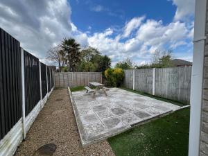 a bench sitting in a yard next to a fence at Great 4 bedroom House - Great Location - Garden - Parking - Fast WiFi - Smart TV - Newly decorated - sleeps up to 8! Only 10 mins drive to Sandbanks Beach! Close to Poole & Bournemouth in Parkstone